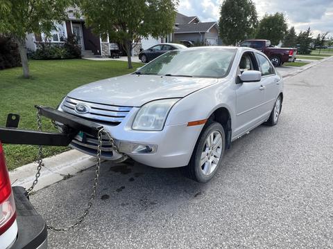 Towing a Silver Sedan for Scrap Metal Recycling