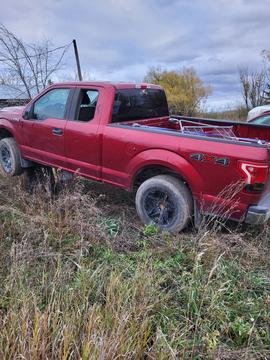 Red Pickup Truck with Scrap Metal in Rural Setting