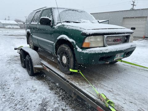 Snow-Covered SUV Secured on Trailer for Scrap Metal Pickup