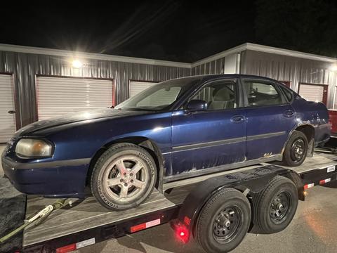 Old Sedan Loaded on Trailer for Scrap Metal Recycling