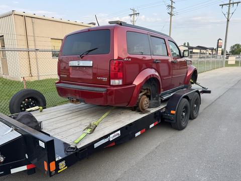 Red SUV Loaded on Trailer for Scrap Metal Recycling