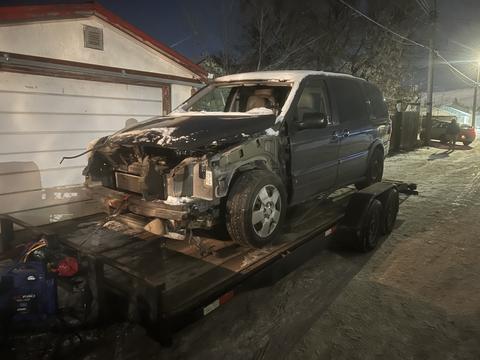 Old Minivan Ready for Scrap Metal Recycling on Trailer