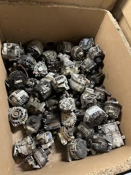 Scrap Metal Recycling: Collection of Used Alternators in a Cardboard Box